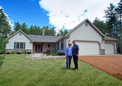 Exterior of a house with homeowners standing on the lawn