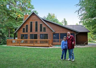 Exterior of a log cabin house and homeowners